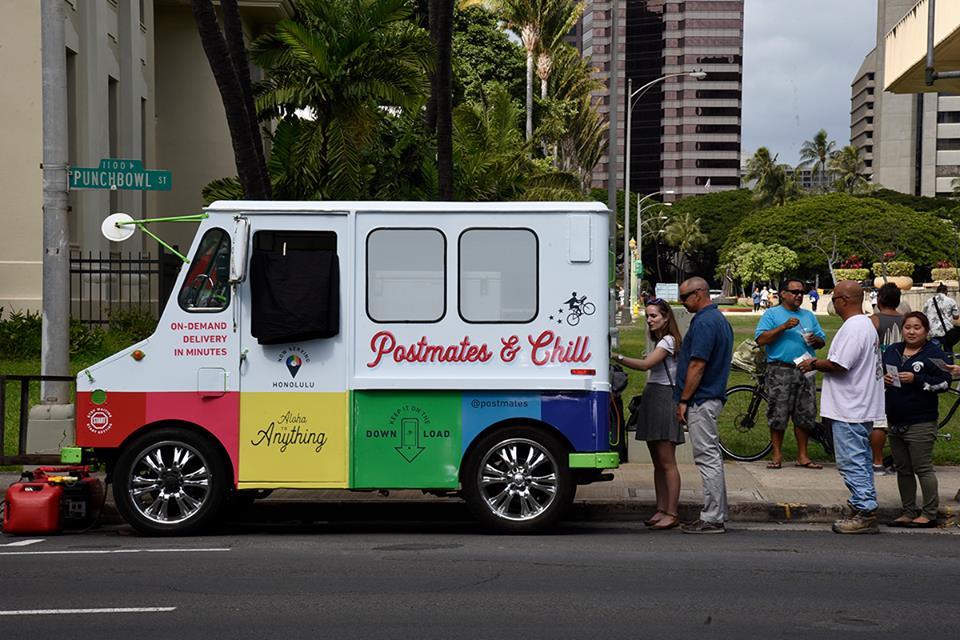 A photo of a Postmates van delivering food to people in the US.